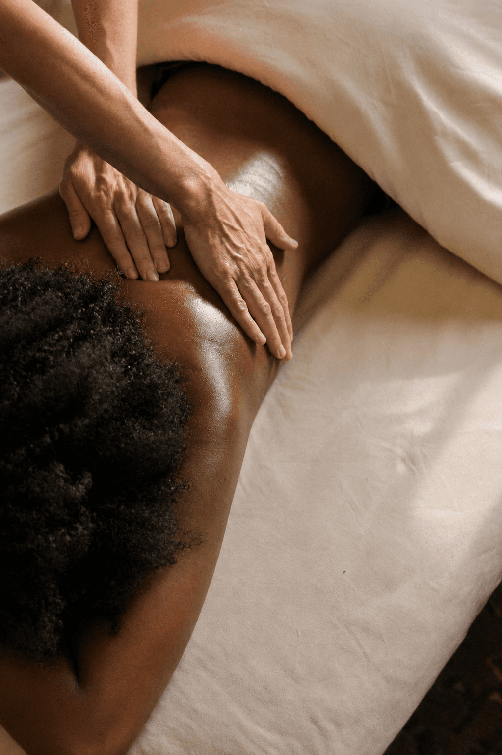 hands massaging a back with oil, relaxation